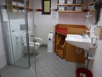 Blick in die Behindertentoilette mit Wickeltisch und Dusche ( seitlich links )