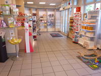 Blick in den Verkaufsraum in Richtung Haupteingang mit den Verkaufsregalen und einem Kinderschaukelpferd rechts